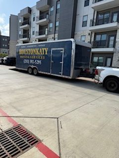 A houstonkaty trailer is parked in a parking lot next to a building.