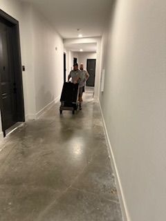 Two men are pushing a cart down a hallway.