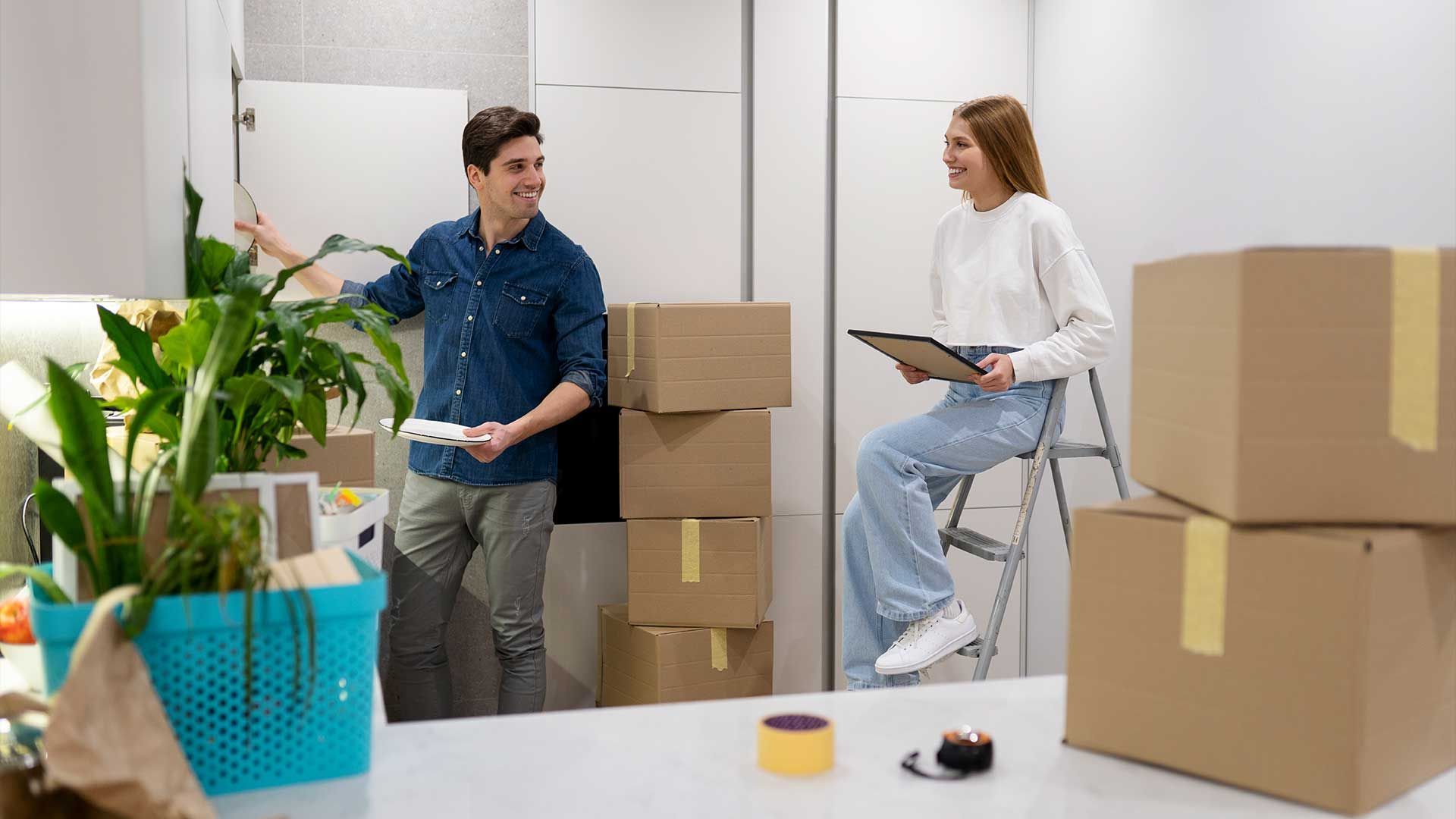 A man and a woman are standing next to each other in a room filled with boxes.