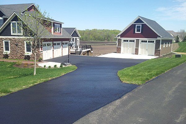 A driveway leading to a house with two garages.