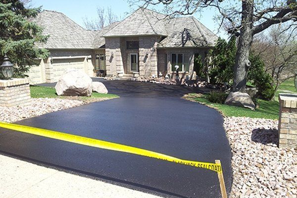 A large house with a black driveway and a yellow tape on it
