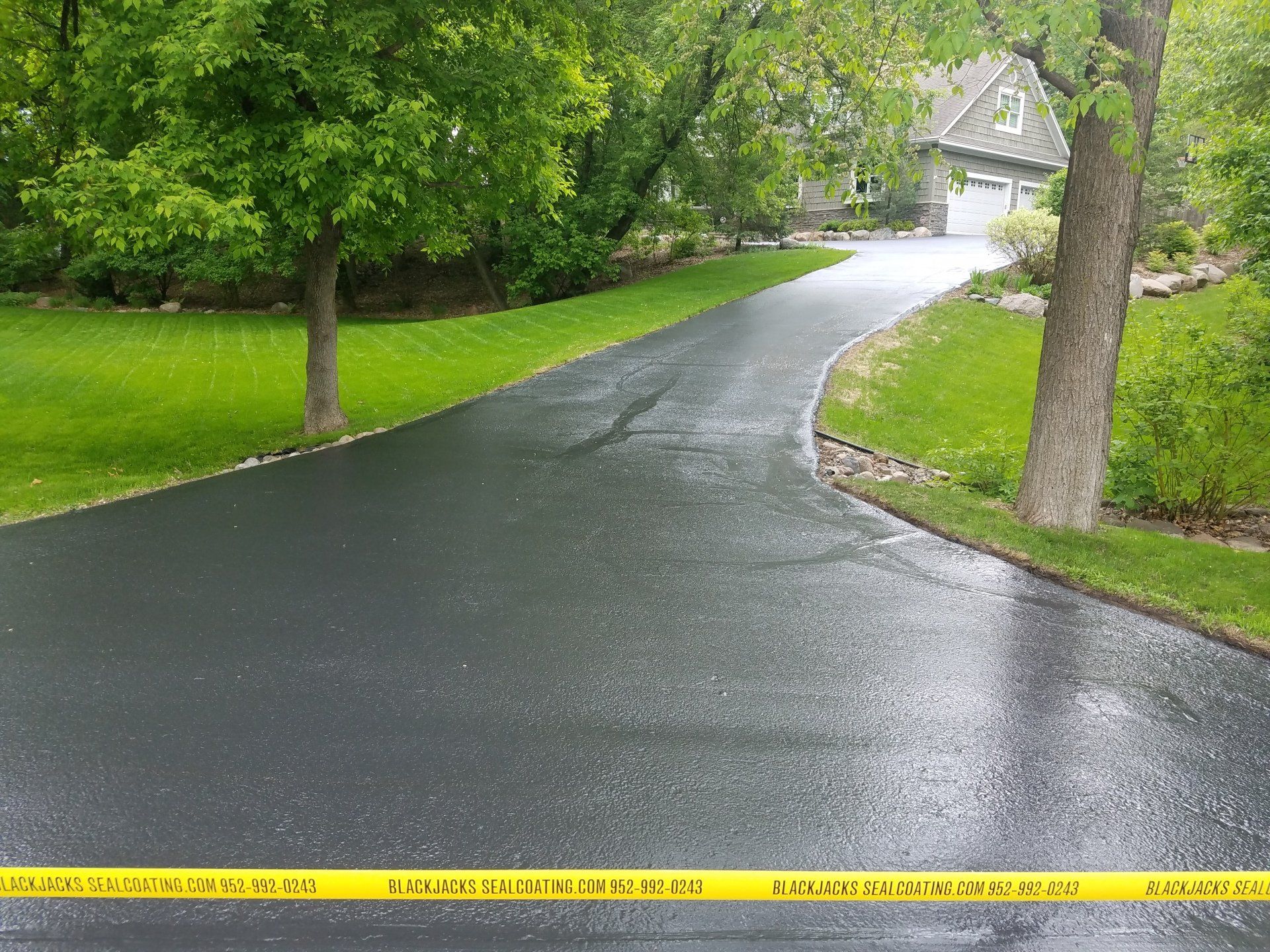 A driveway leading to a house with trees on both sides.