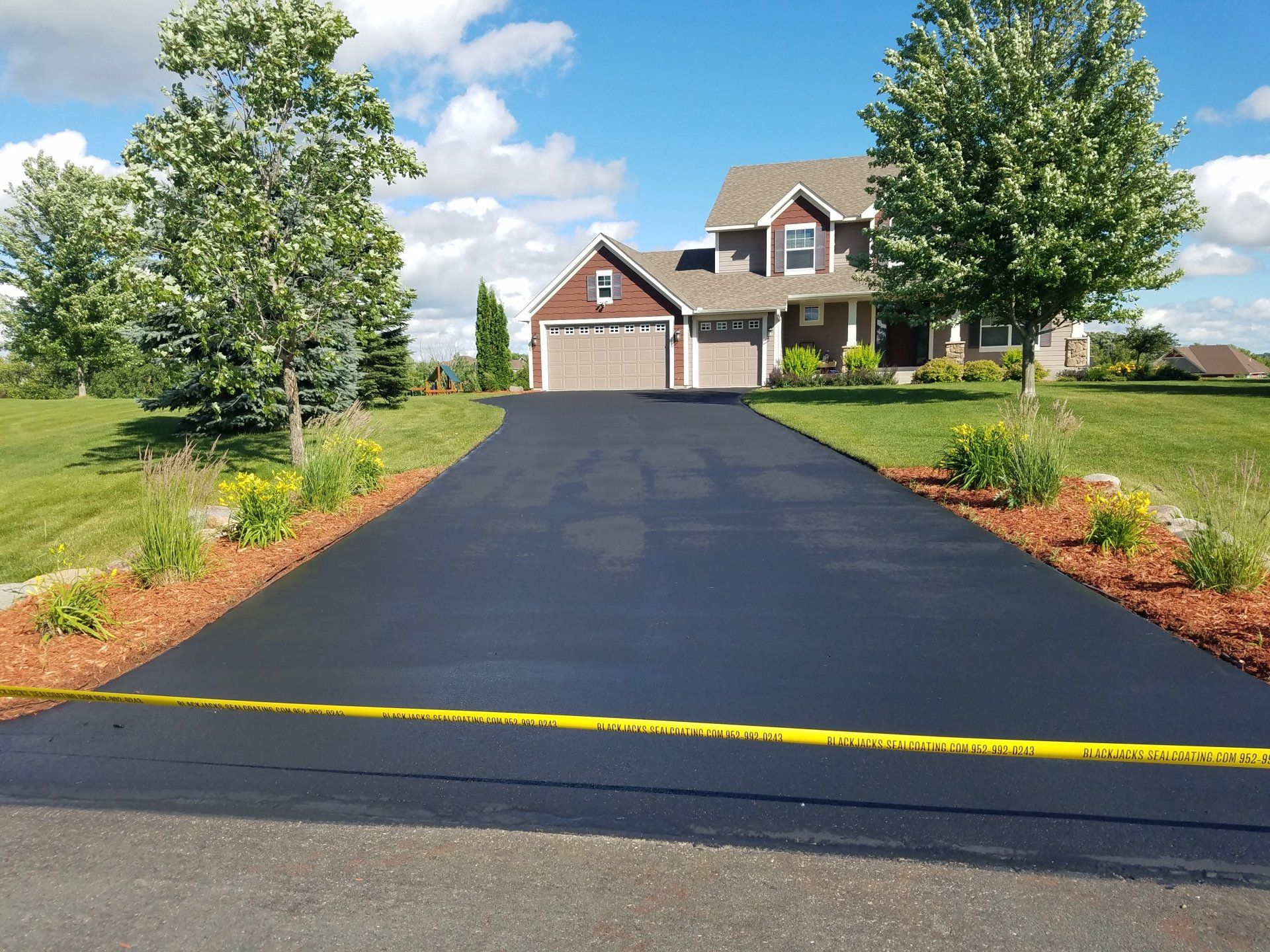 A driveway leading to a house with a yellow caution tape on it