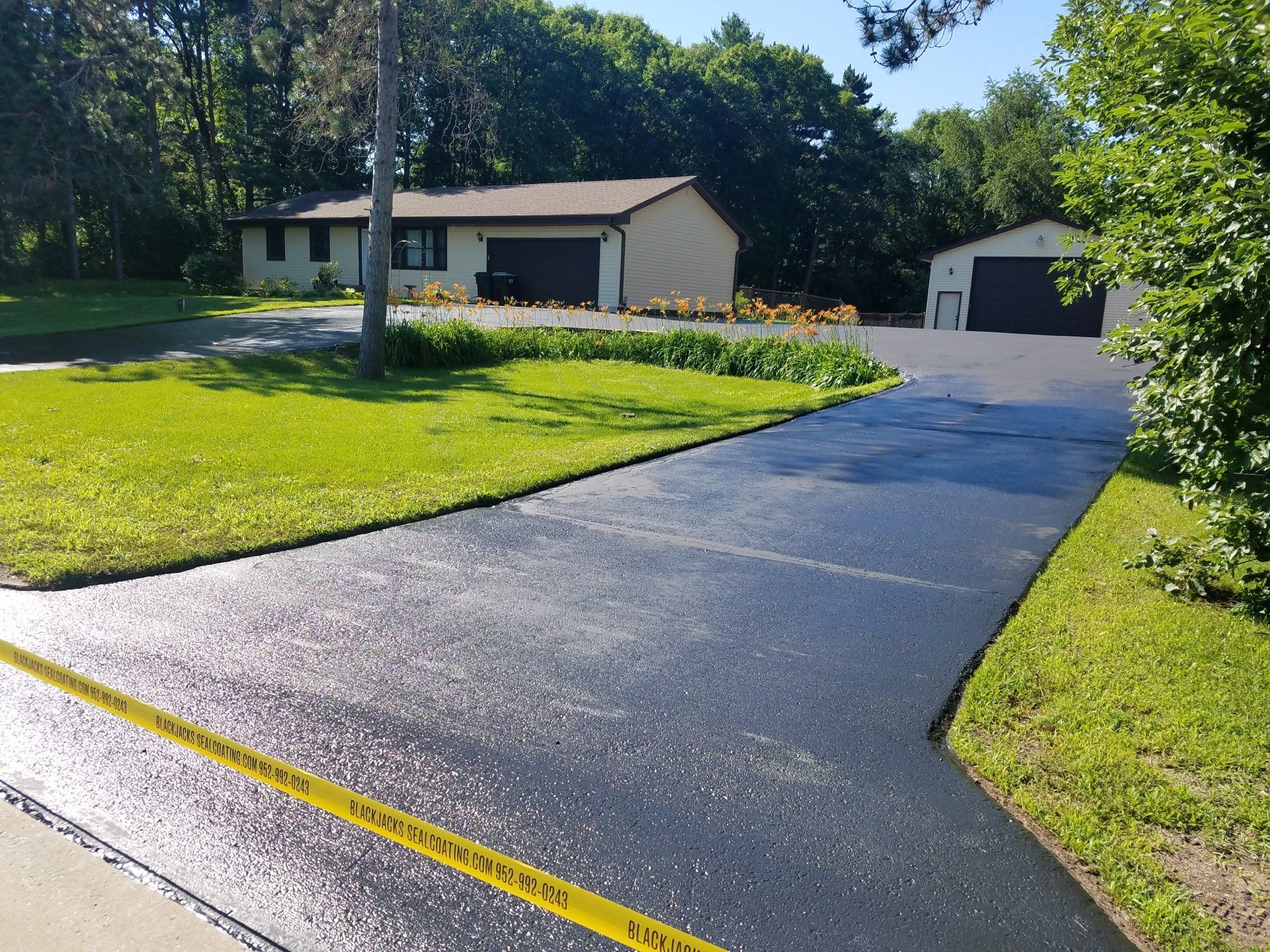 A driveway leading to a house with a yellow caution tape on it