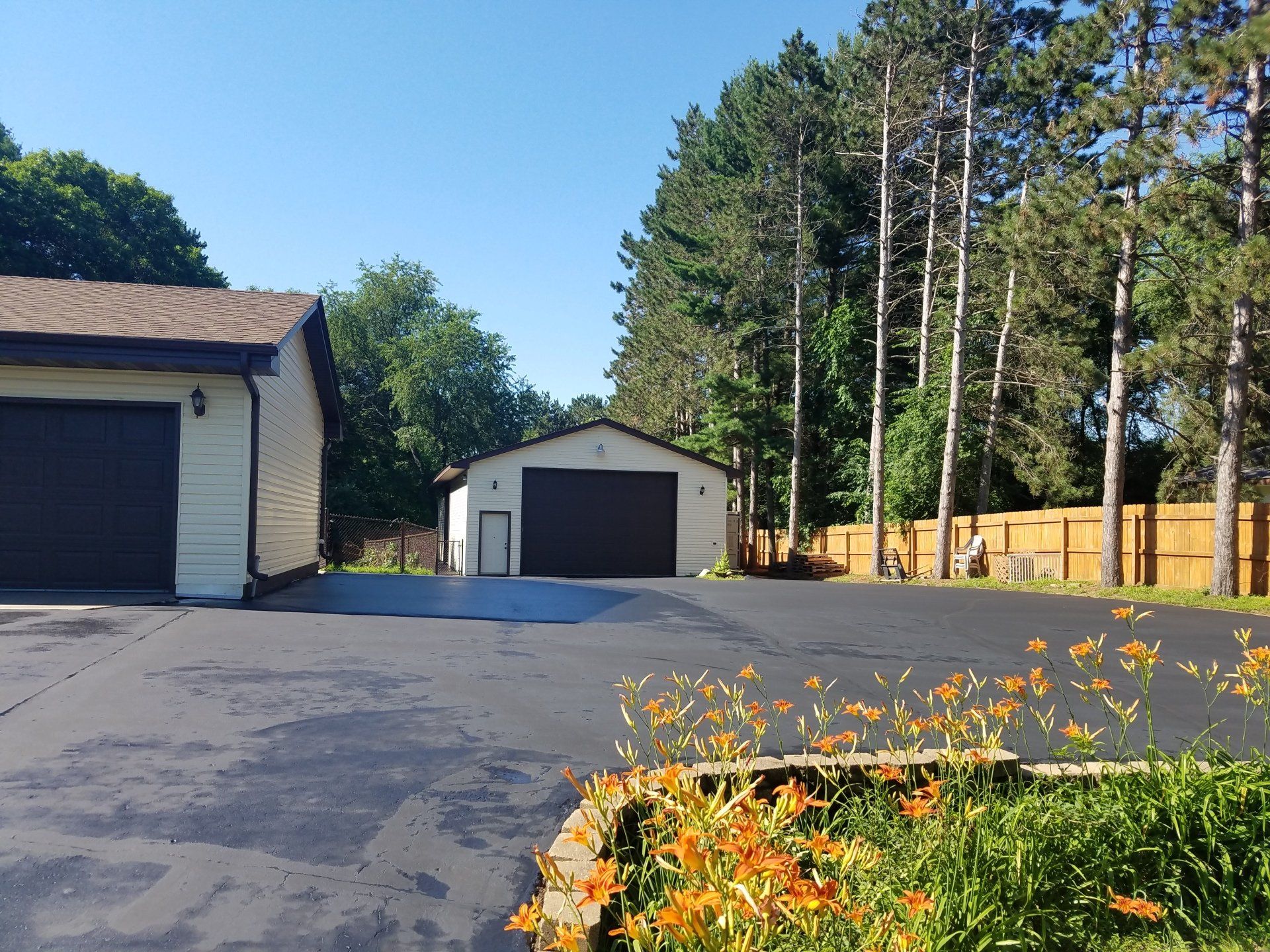 A driveway with a garage and a house in the background