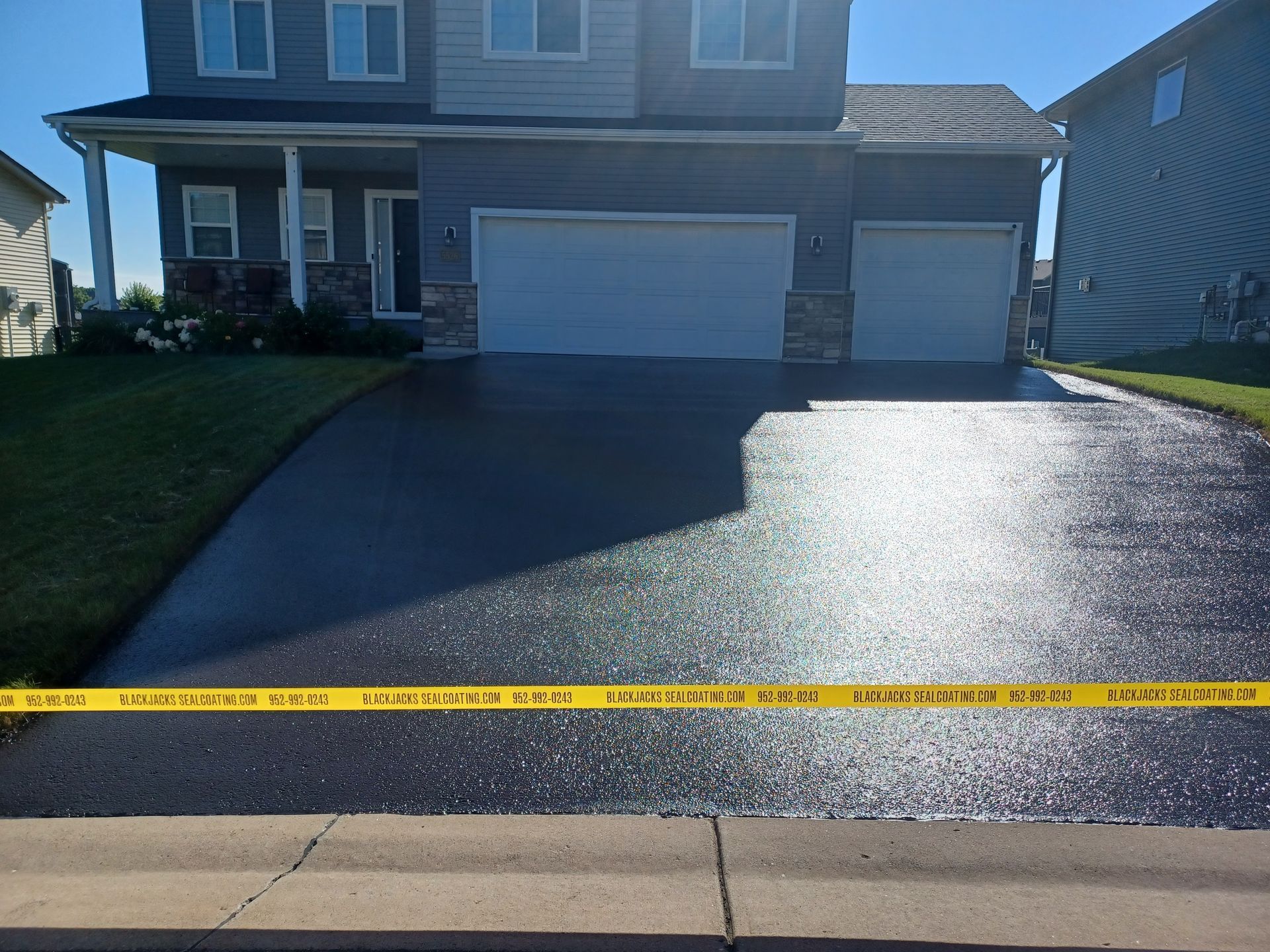 A driveway with a yellow tape that says ' asphalt ' on it