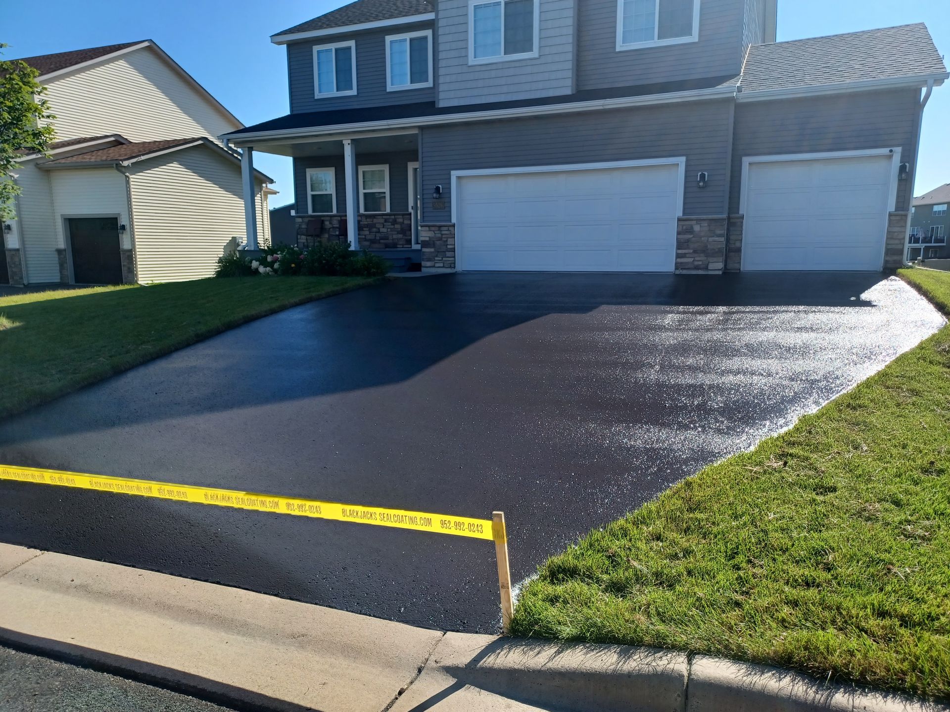 A driveway is being paved in front of a house.