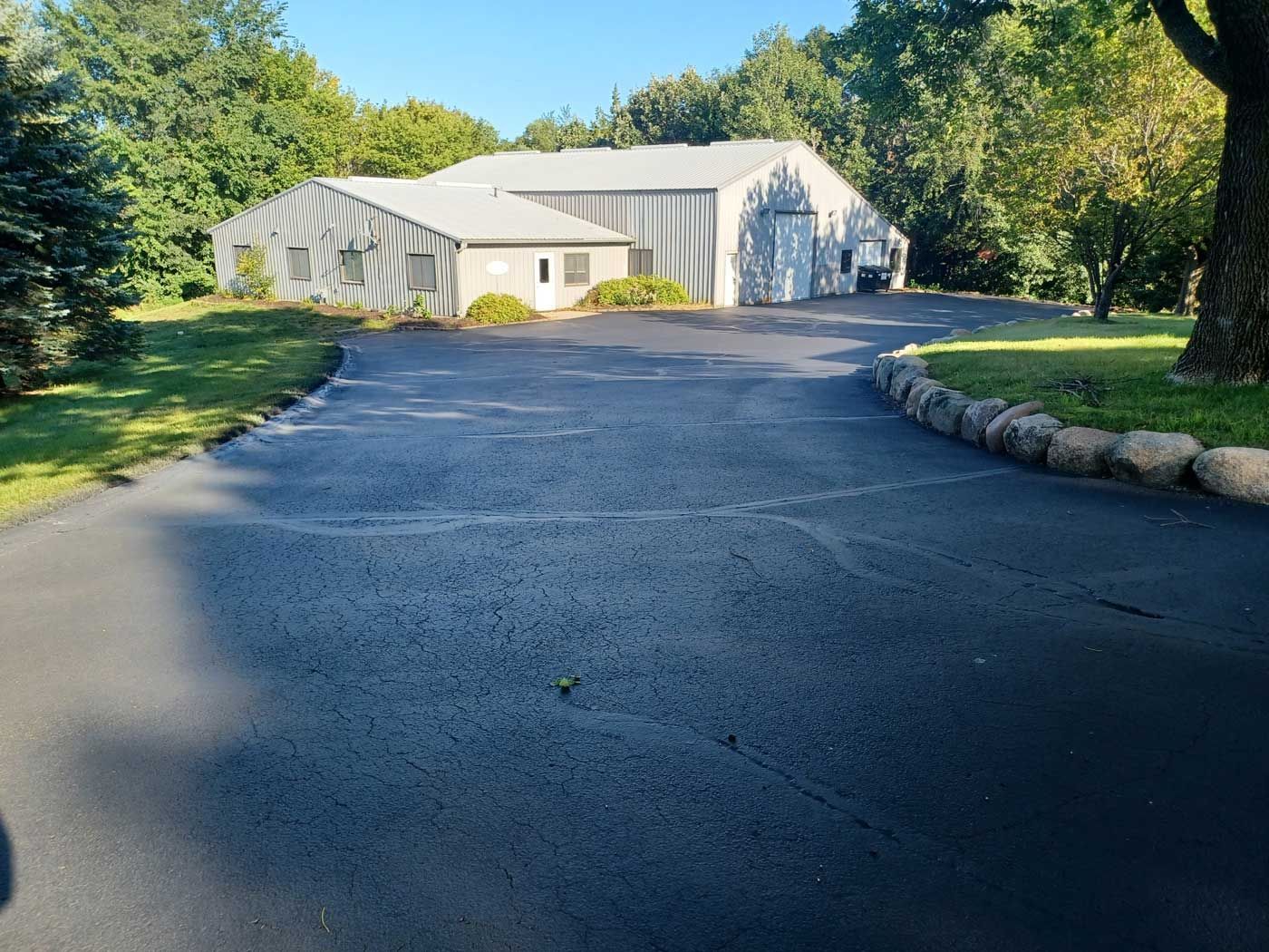 A driveway leading to a house with a garage in the background.