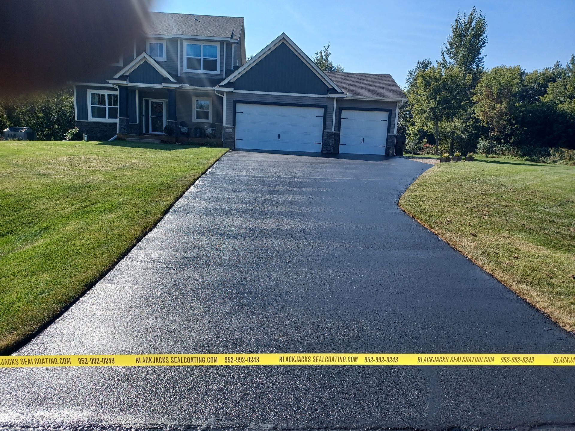 A driveway leading to a large house with two garages
