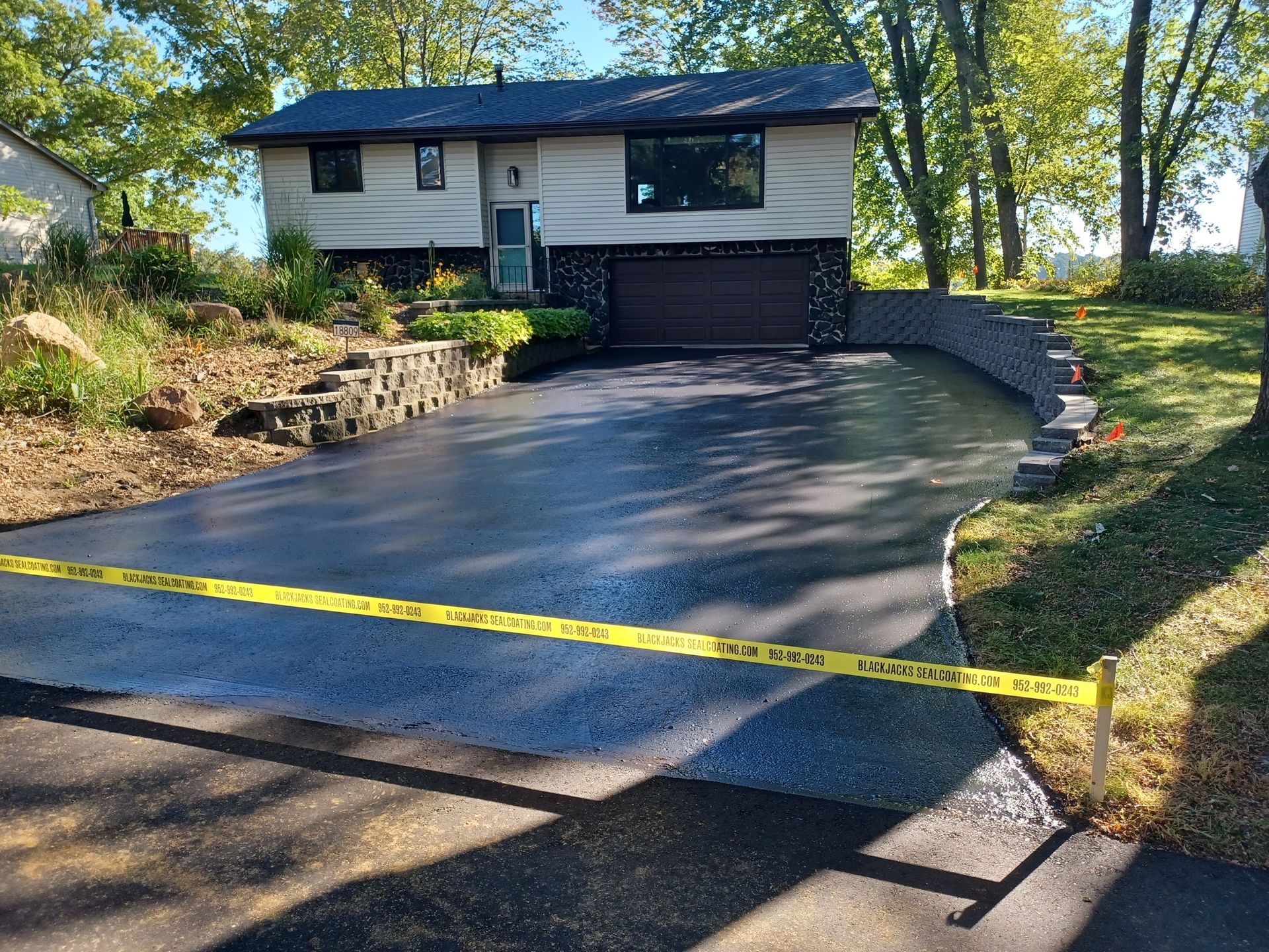 A house with a large driveway and a yellow tape surrounding it.
