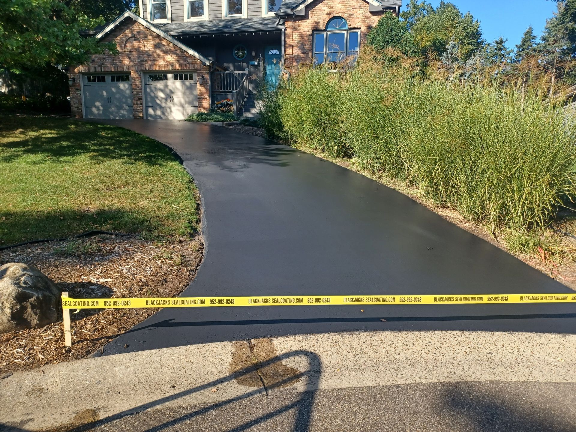 A brick house with a concrete driveway in front of it