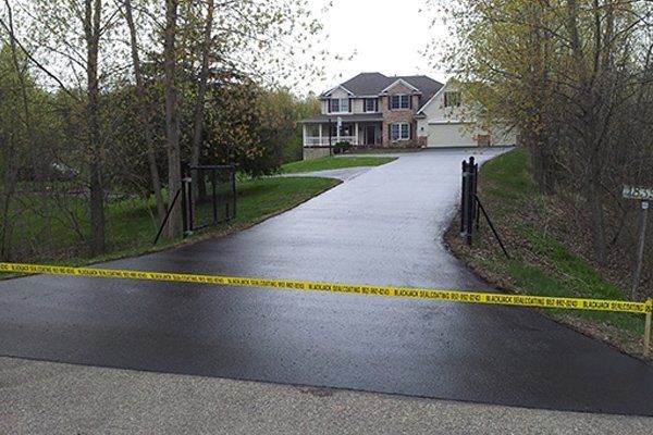 A large house is behind a closed driveway