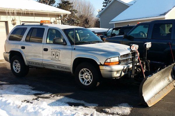 A snow plow is attached to a silver suv