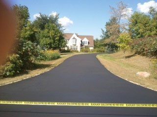 A residential driveway with a large house in the background.