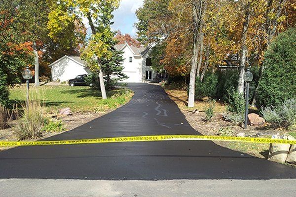 A driveway leading to a house with a yellow tape covering it.