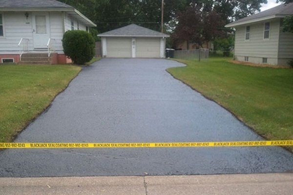 A driveway with a yellow tape that says do not enter