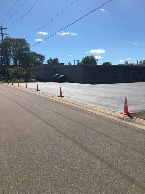 A row of orange traffic cones on the side of a road
