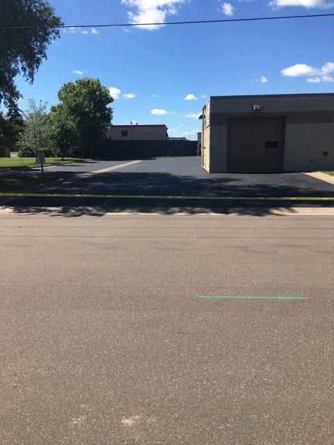 A road with a building in the background on a sunny day