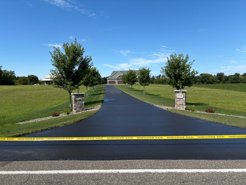 A driveway leading to a house with trees on both sides