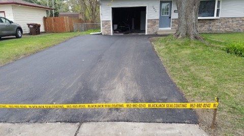 A car is parked in the driveway of a house.