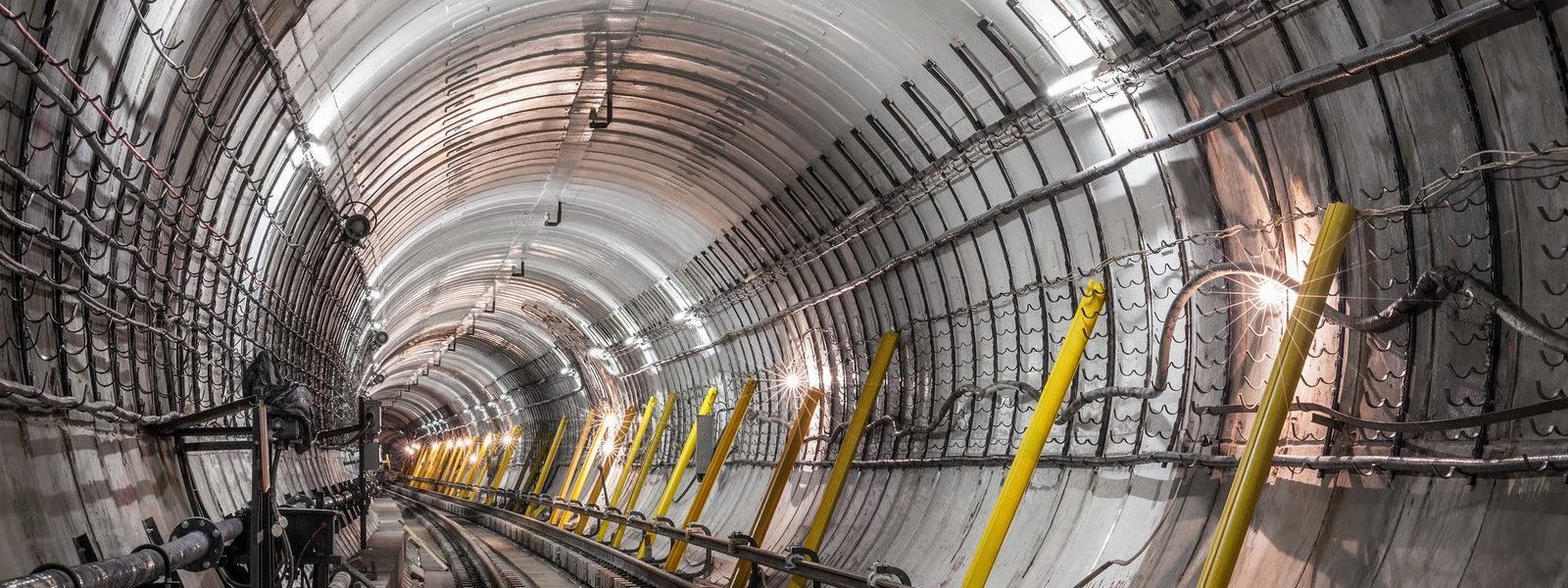 Inside view of a bright blue tunnel, light at the end.