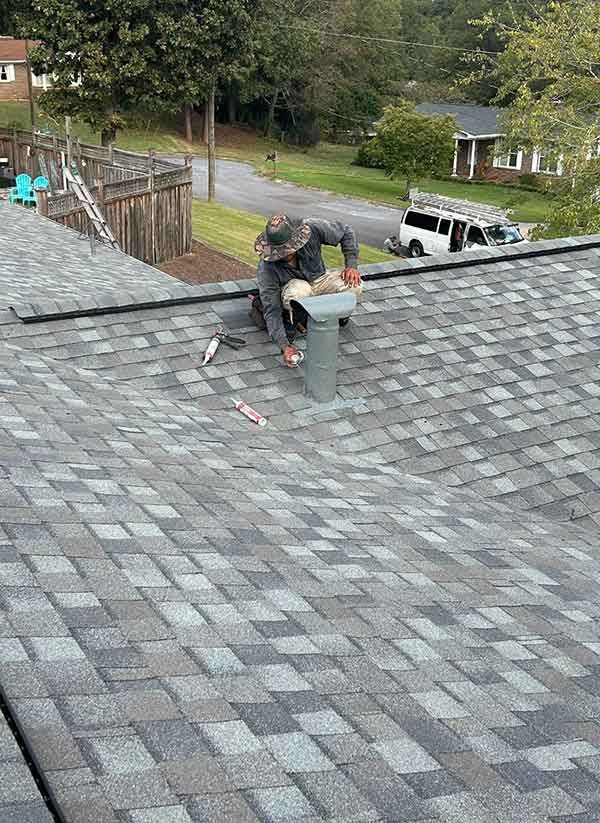 A man is working on the roof of a house.