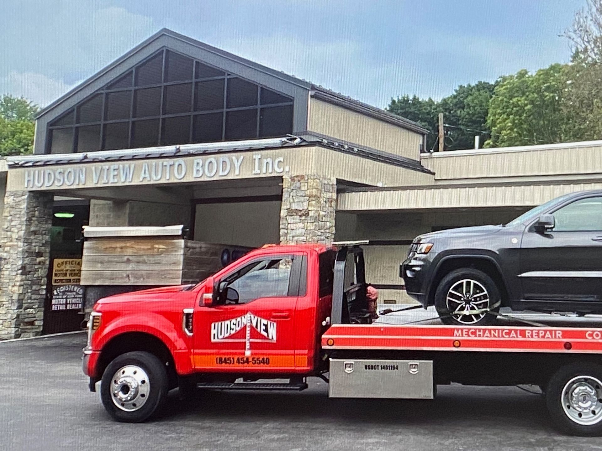 Two tow trucks are parked next to each other in a parking lot.
