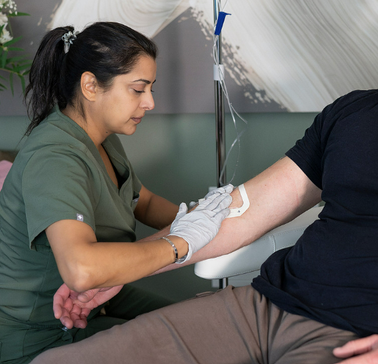 Nurse preparing patient's arm for IV therapy.