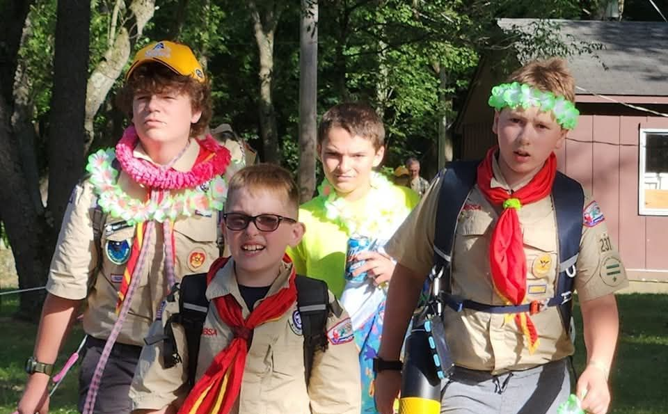 Boys dressed in Island attire for a celebration at the waterfront in a camp setting.