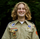 Young man in Boy Scout uniform smiles at the camera.