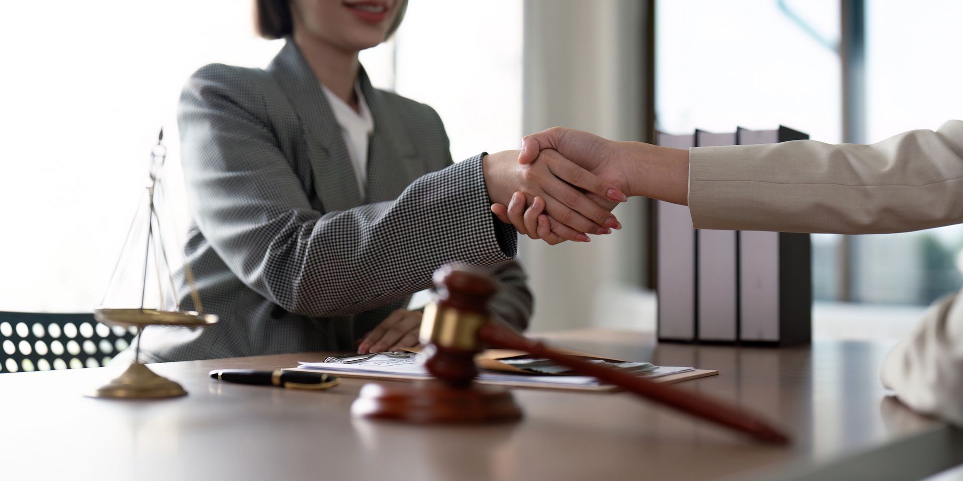 Una mujer le da la mano a otra mujer mientras está sentada en una mesa.