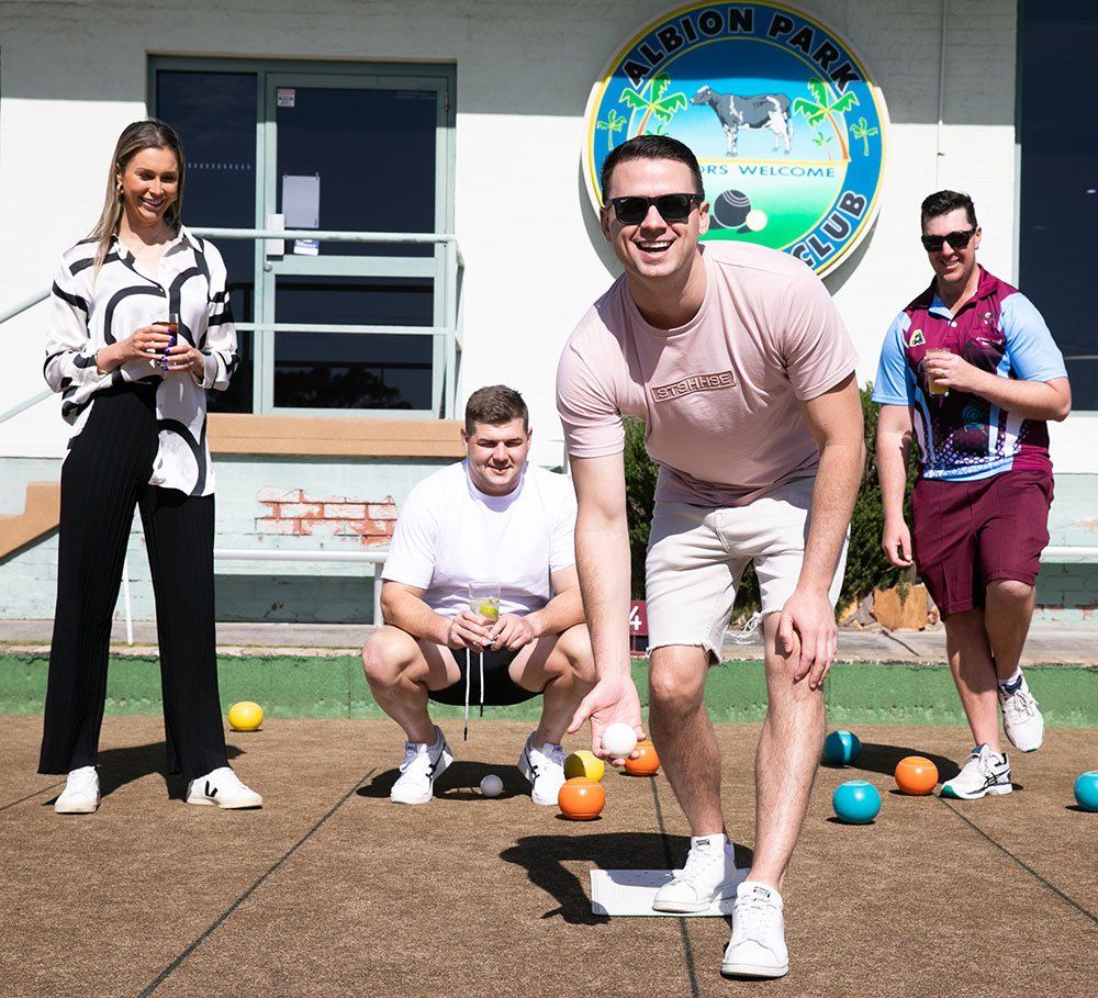 a group of young adults playing barefoot bowls