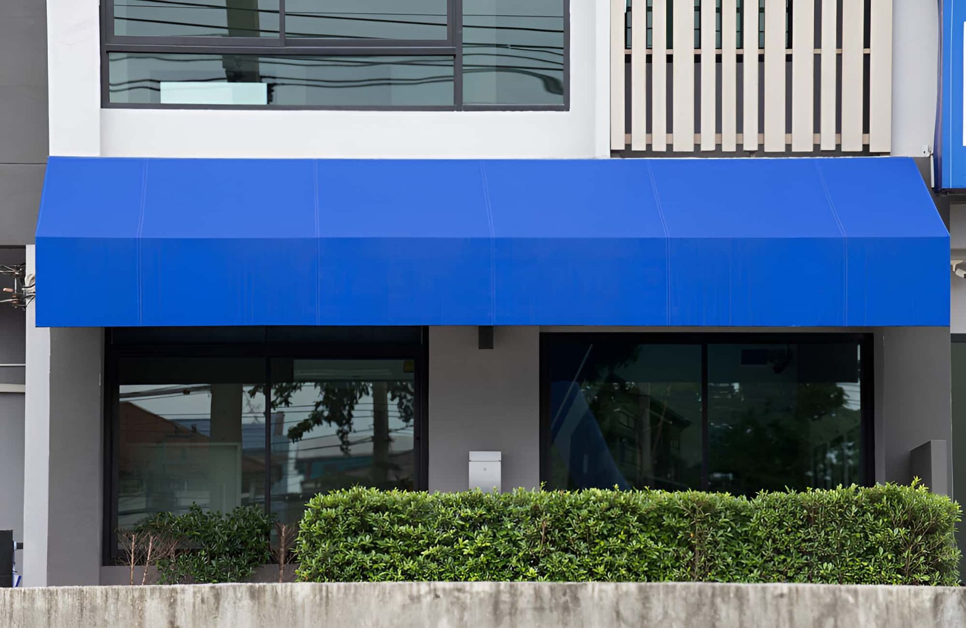 A Blue Awning Is Hanging Over The Front Of A Building — All Hours Glass In Greenwell, NSW