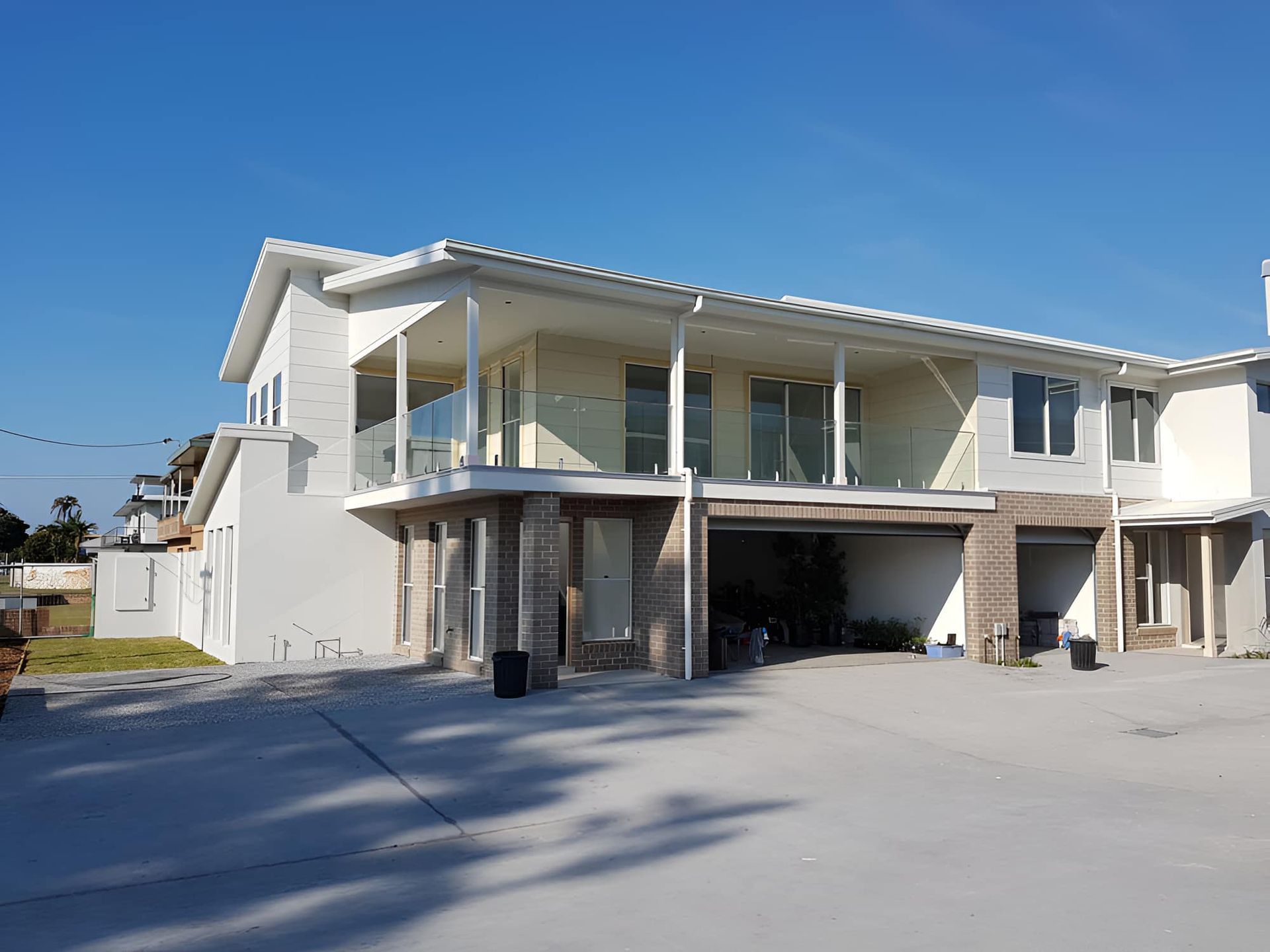 A Large White House With A Lot Of Windows And A Balcony — All Hours Glass In Culburra Beach, NSW