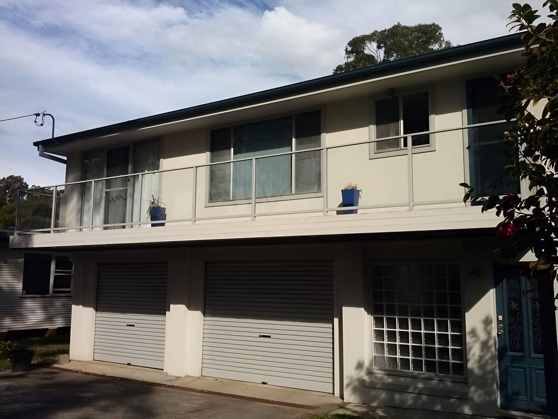 A White House With A Balcony And A Blue Door — All Hours Glass In Culburra Beach, NSW