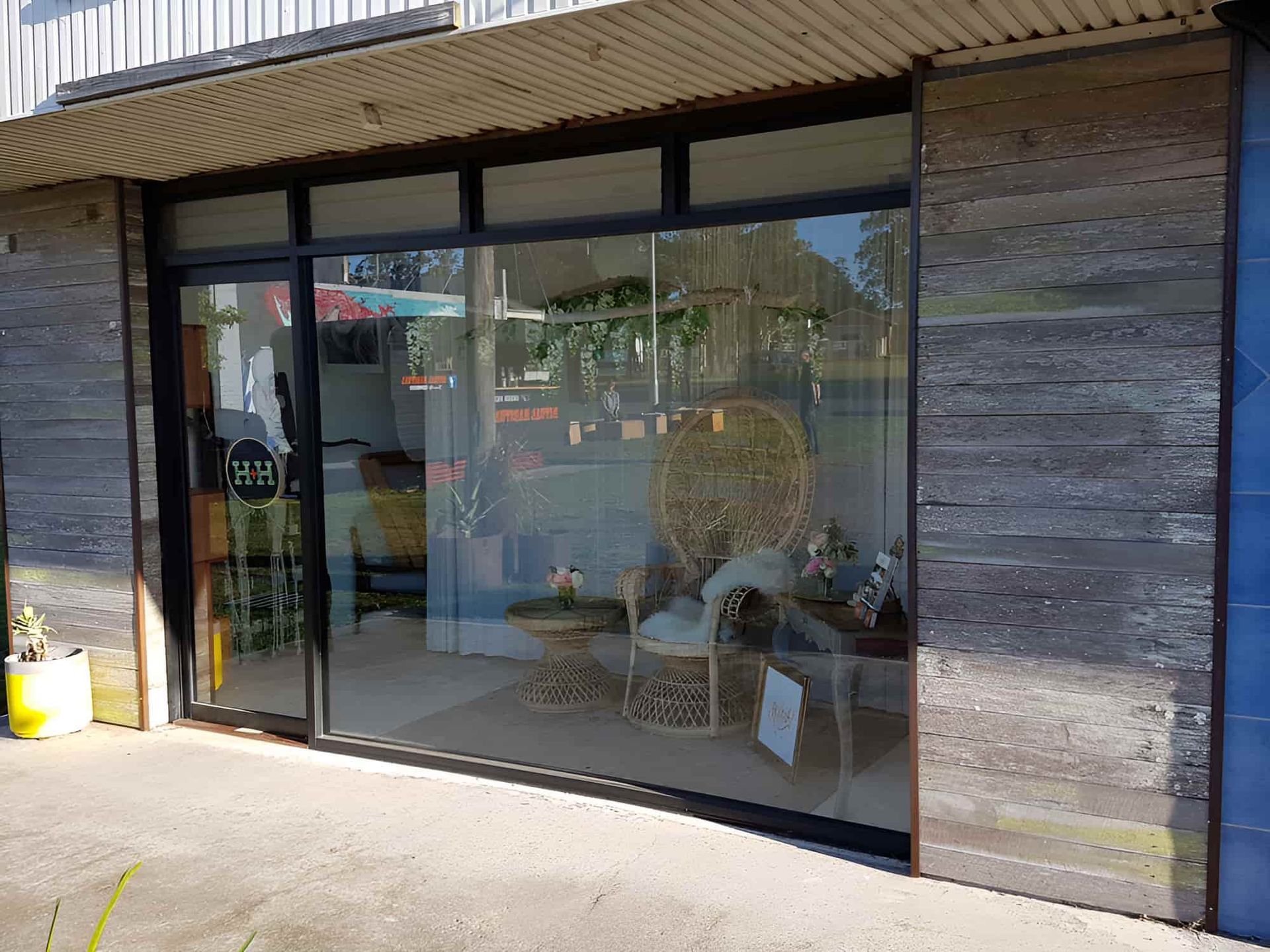 A Store Front With A Lot Of Windows And A Chair In Front Of It — All Hours Glass In Culburra Beach, NSW