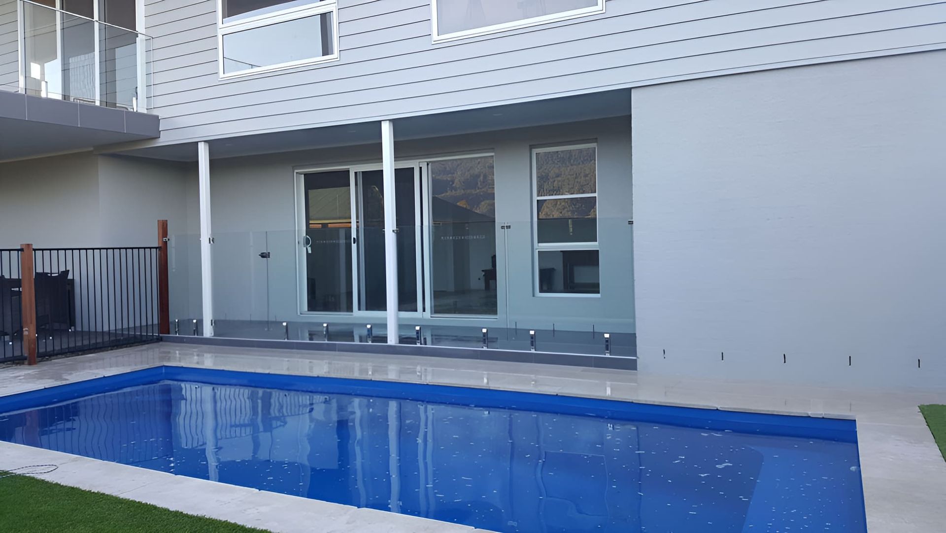 A Large Swimming Pool Is In The Backyard Of A House — All Hours Glass In Culburra Beach, NSW