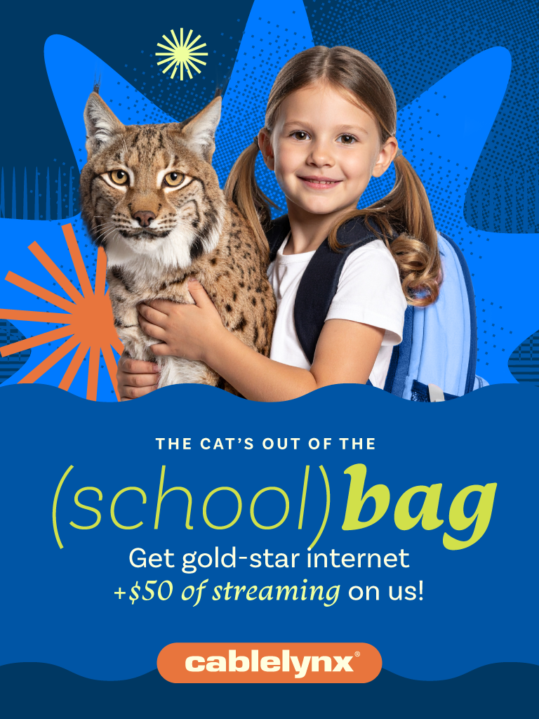 A little girl is holding a cat in her arms.