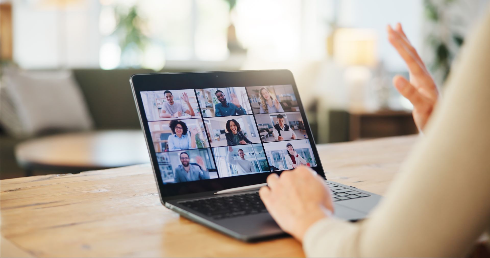 Person on a laptop video call in a bright home setting