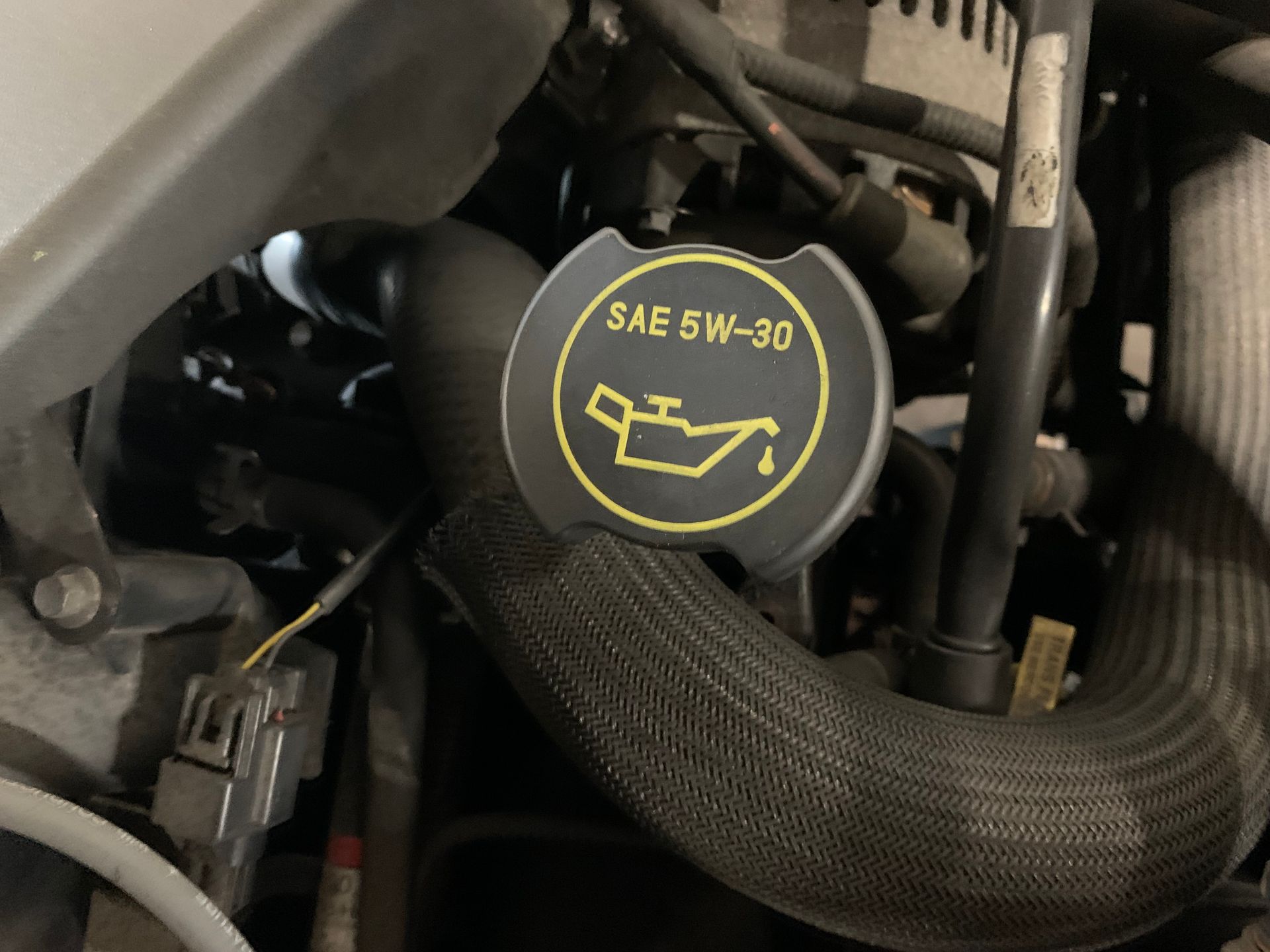 A close up of a sae 5w-30 oil cap | Lou's Car Care Center, Inc.