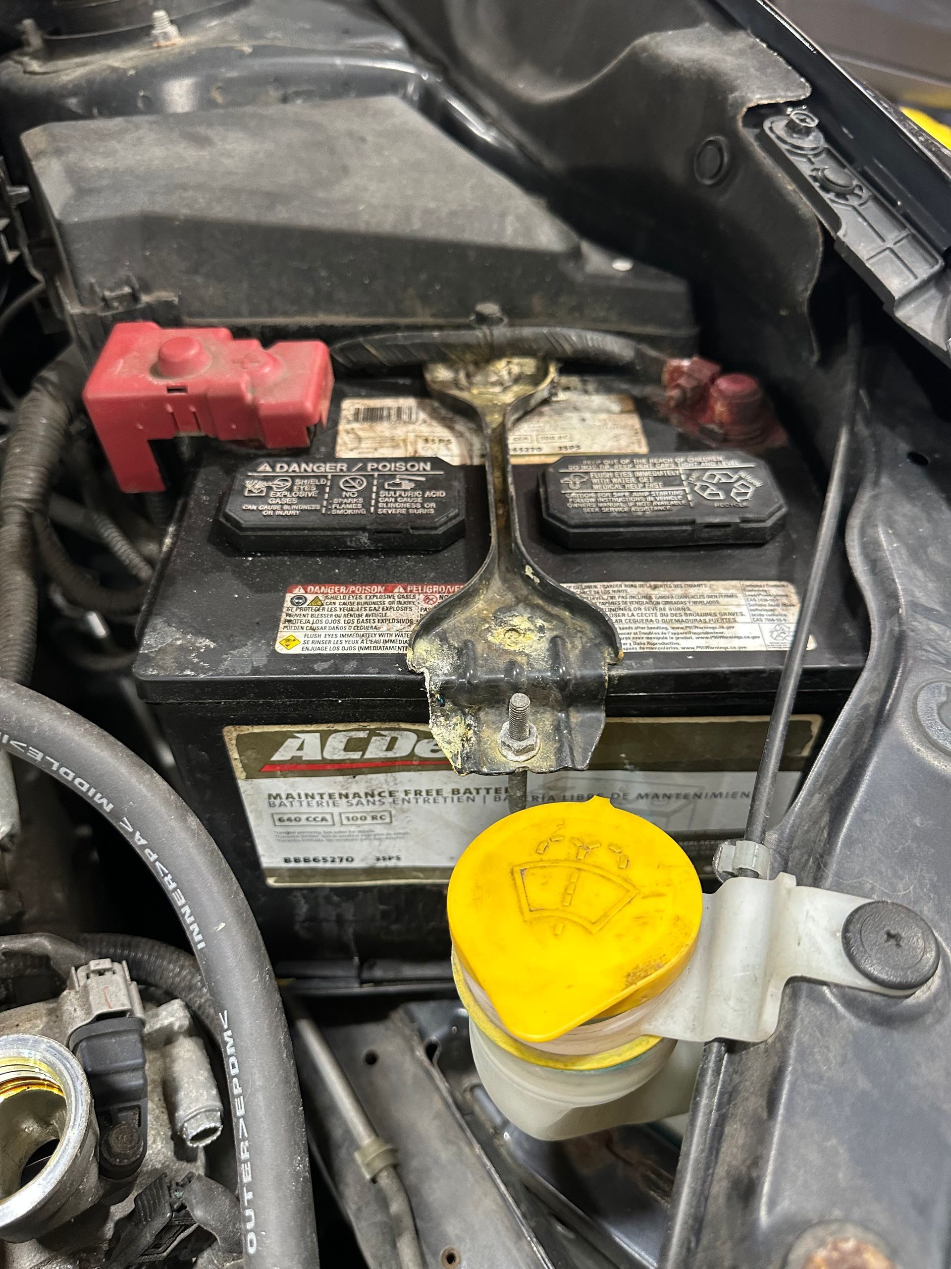 AC Delco battery in vehicle engine bay compartment.