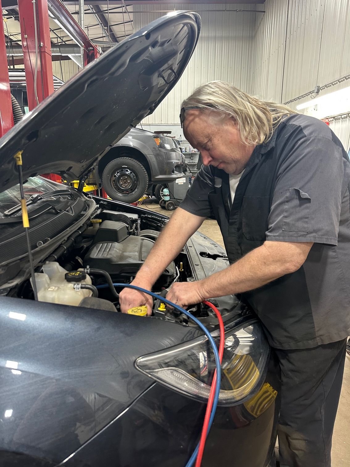 Auto Technician Attaching AC Recharge Machine To Car | Lou's Car Care Center, Inc.