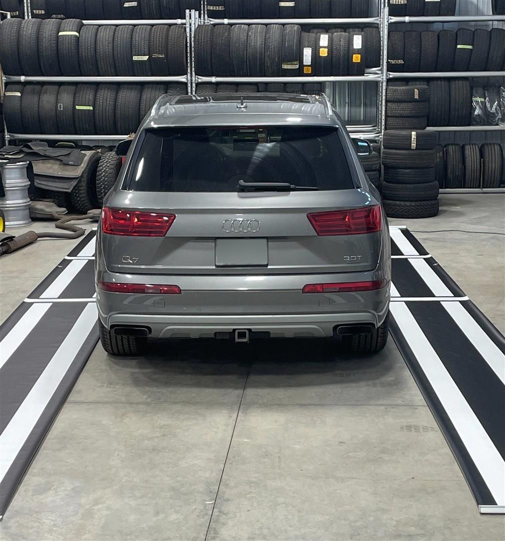 A silver audi is parked in a tire store | Lou's Car Care Center, Inc.