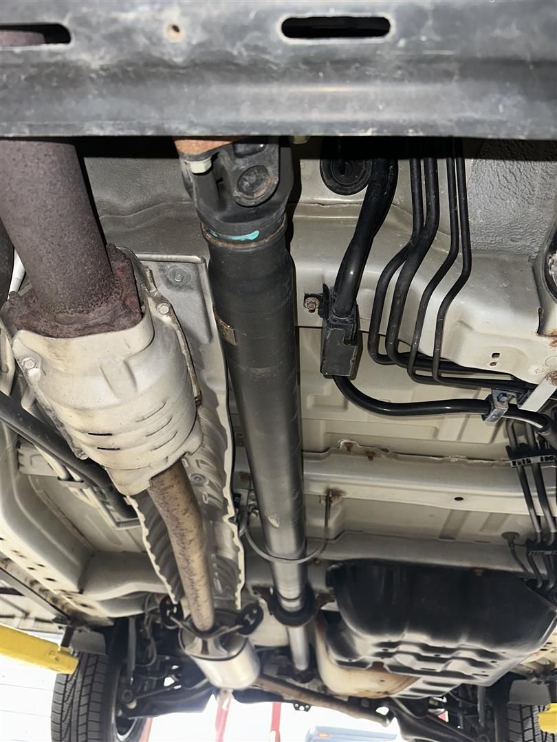 A close up of the underside of a car on a lift. | Lou's Car Care Center, Inc.