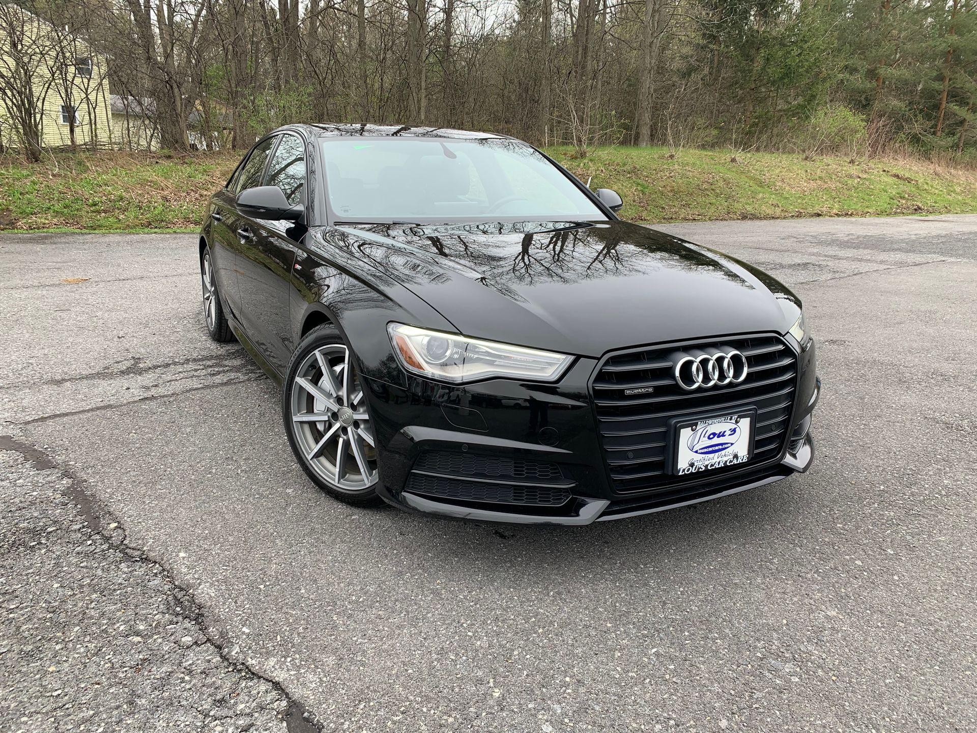 A black audi a6 is parked on the side of the road. | Lou's Car Care Center Inc.