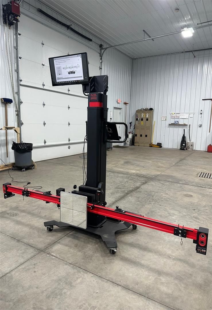 A machine is sitting in a garage next to a garage door. | Lou's Car Care Center, Inc.