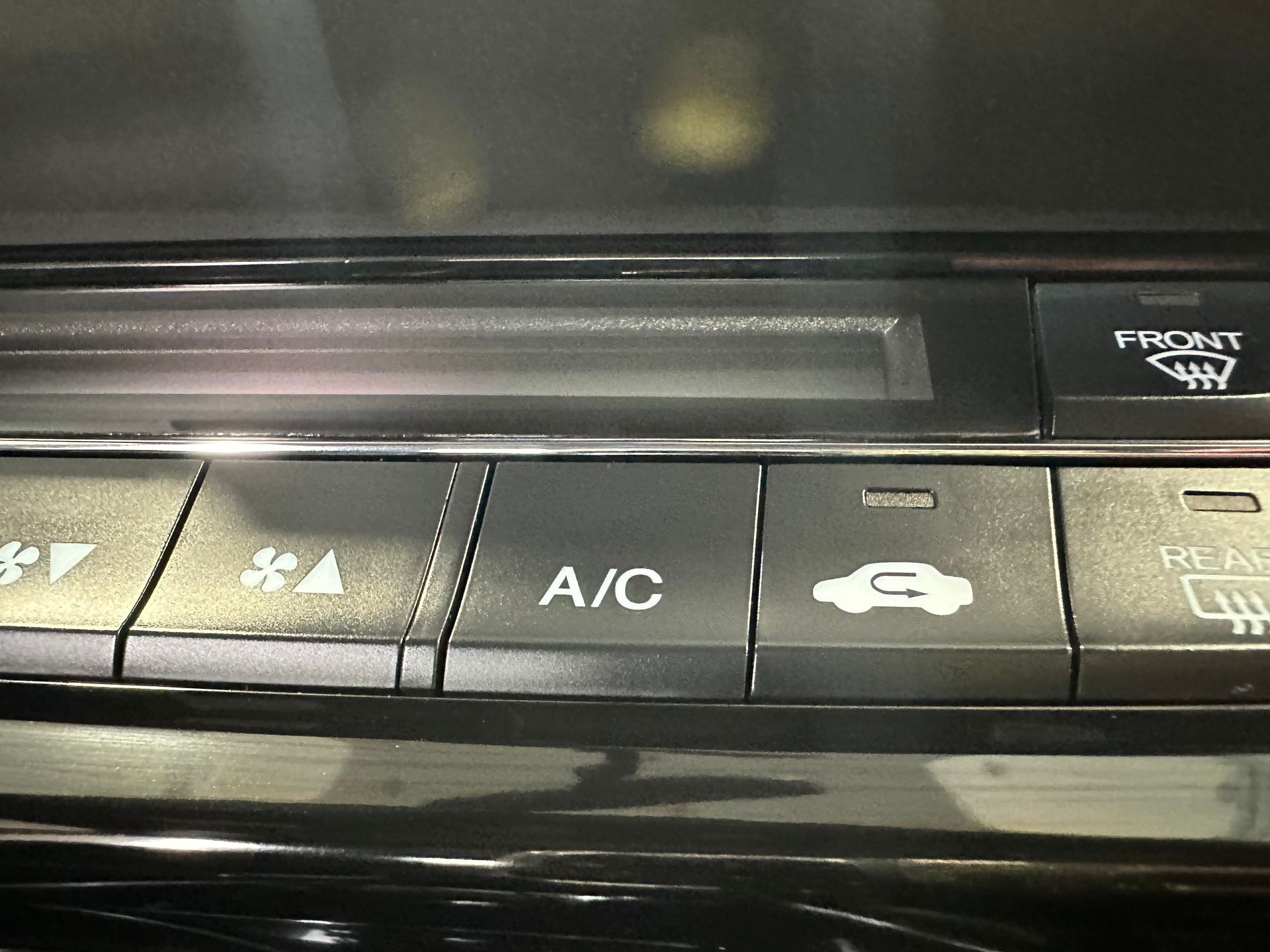 A close up of a a/c button on a car | Lou's Car Care Center