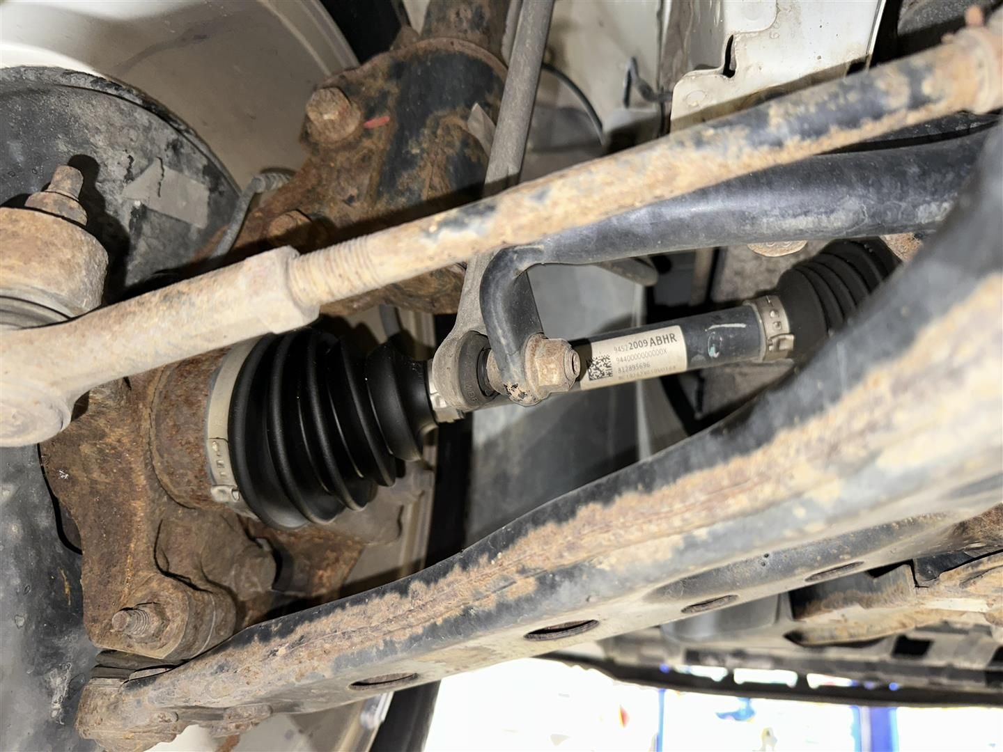 A close up of the underside of a car showing the drive shaft.  | Lou's Car Care Center, Inc.