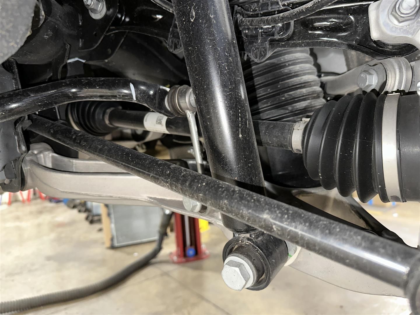 A close up of a car 's suspension system in a garage. | Lou's Car Care Center, Inc.