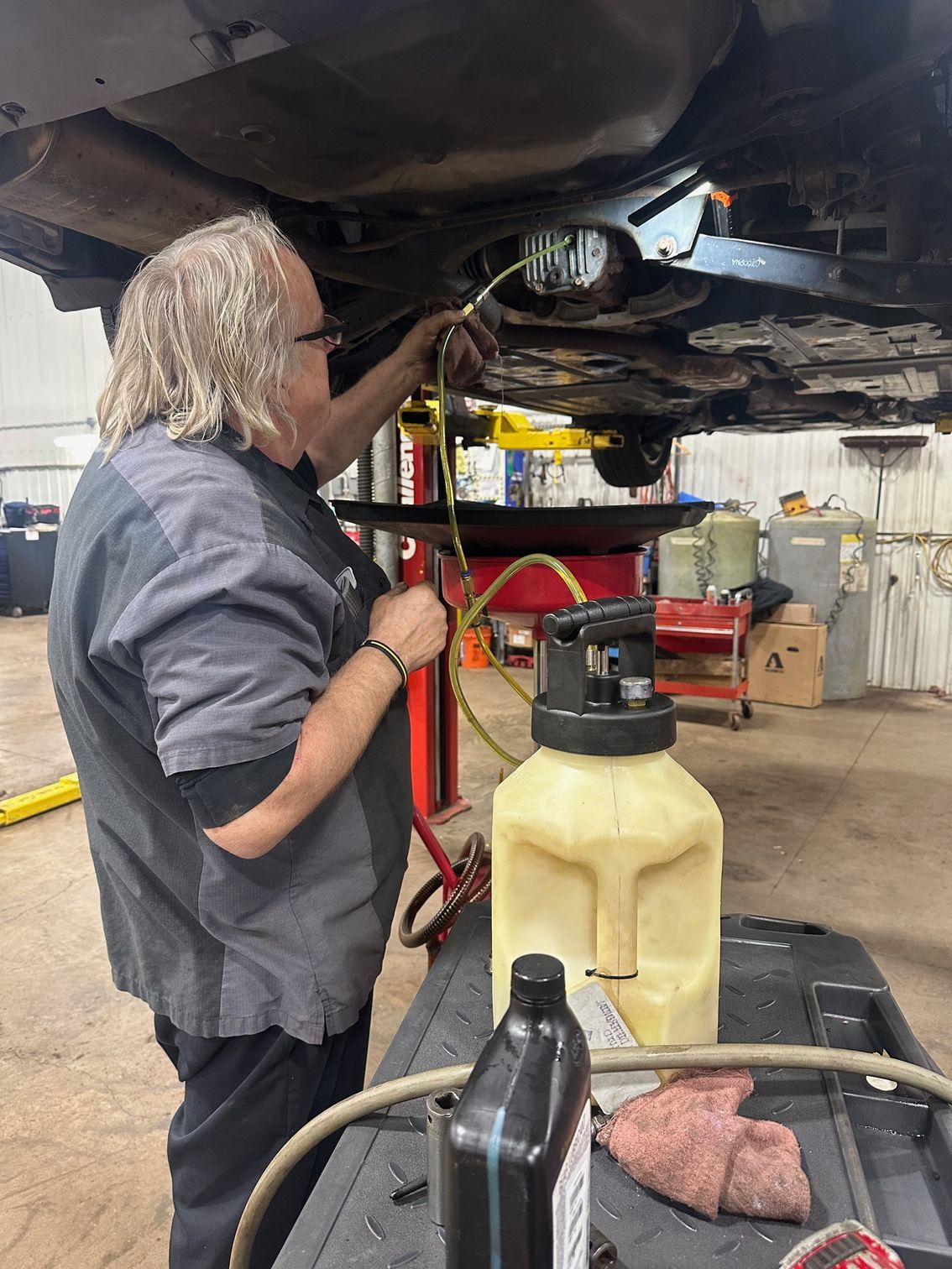 Technician performing differential service on a vehicle.